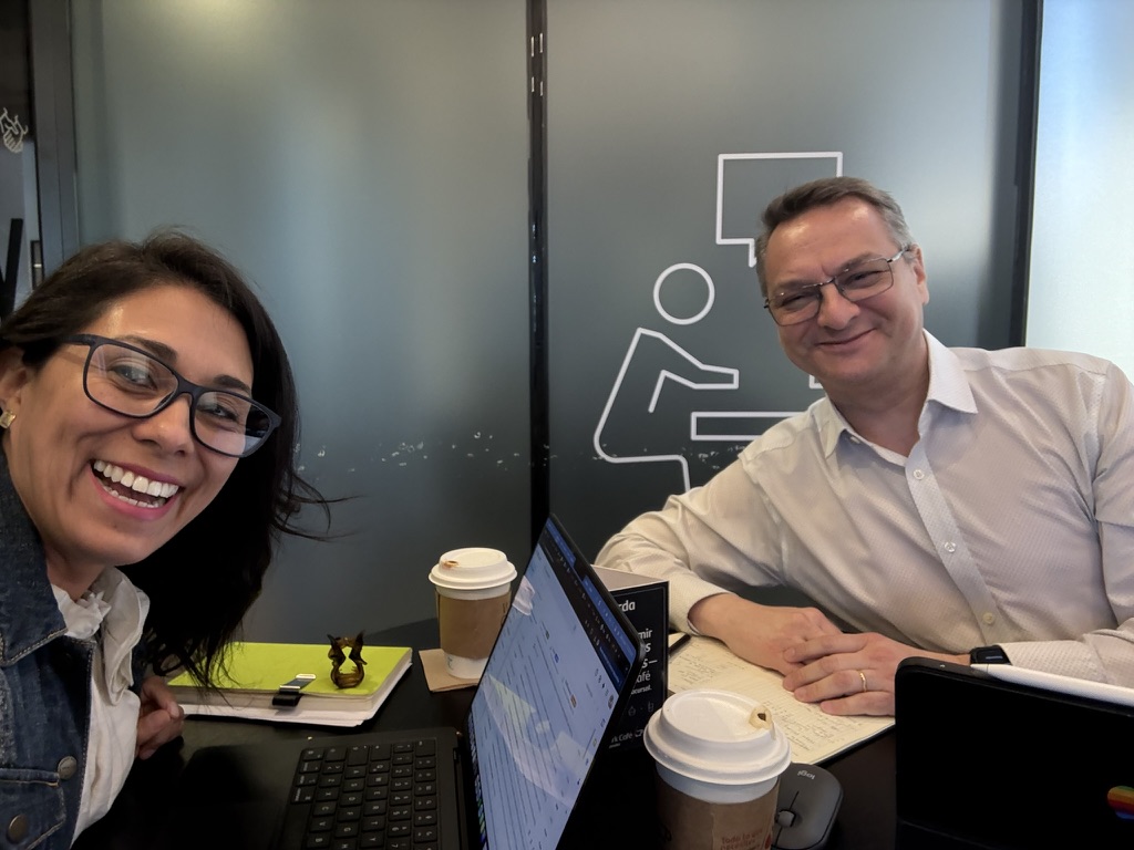 Francisca Tagle y Fabio Anziani, socios de TMA Estudio, trabajando juntos en una mesa con computadores y café
